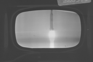 Schwarz-weiß-Foto eines Fernseherbildschirms mit Rakete im Fenster und Text oben.