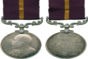 Silberne Medaille mit lila und gelbem Band, mit einem Profilbild auf der linken Seite und dem Text "Langjähriger Einsatz und guter Leumund" auf der rechten Seite.