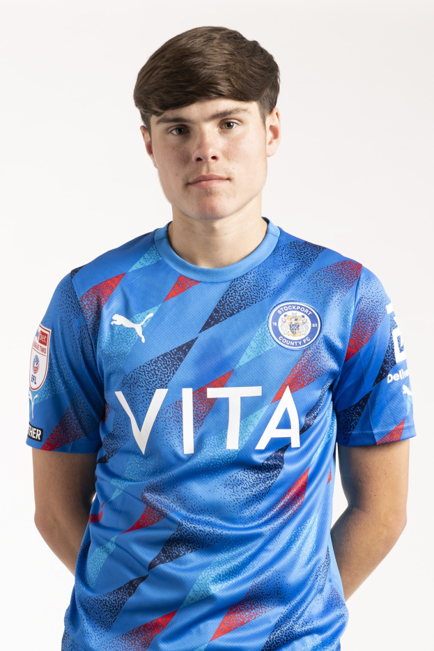 Ein junger Mann in einem blauen und roten Leicester City Away Kit für die Saison 2018-19 steht vor einem weißen Hintergrund.