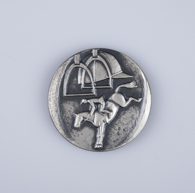 Eine detailliert gravierte Silbermedaille mit einem Reiter auf einem Pferd auf einem weißen Hintergrund.