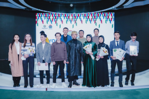 Gruppe von Menschen auf einer Bühne mit Blumensträußen und Urkunden, mit einem Hintergrund, auf dem "Youth Solar Awards 2019" steht.