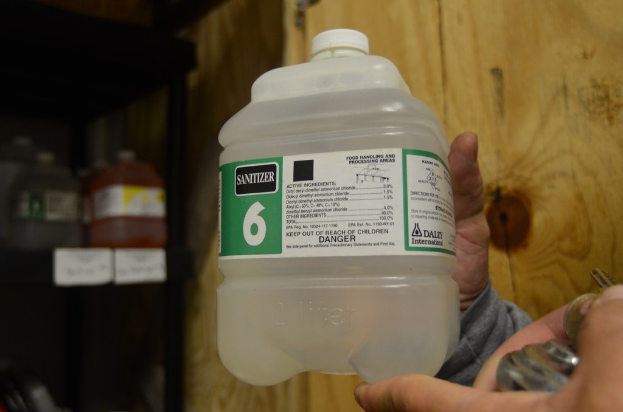 Ein Mann hält eine Flasche Desinfektionsmittel.