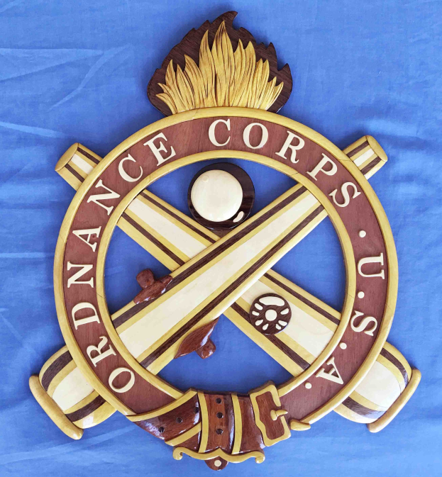 Holzschild mit "Ordnance Corps"-Text, mit einem geschnitzten weißen Stern auf einem navyblauen Hintergrund mit goldener Umrandung, auf blauem Tuch montiert.