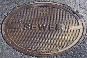 Metall-Schachtreppe auf der Straße mit der eingravierten Aufschrift "Kanal"