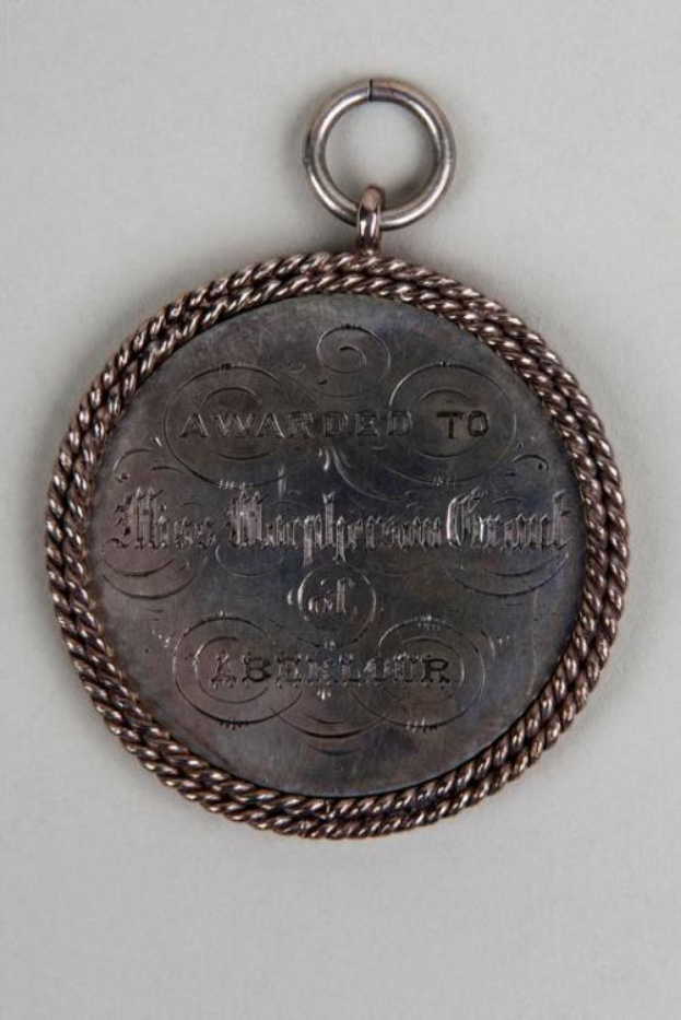 Eine silberne Medaille mit einer Schnur drum herum, mit der Inschrift "Für den Metropolitan Council verliehen" in schwarzer Tinte und einem dekorativen Rahmen.