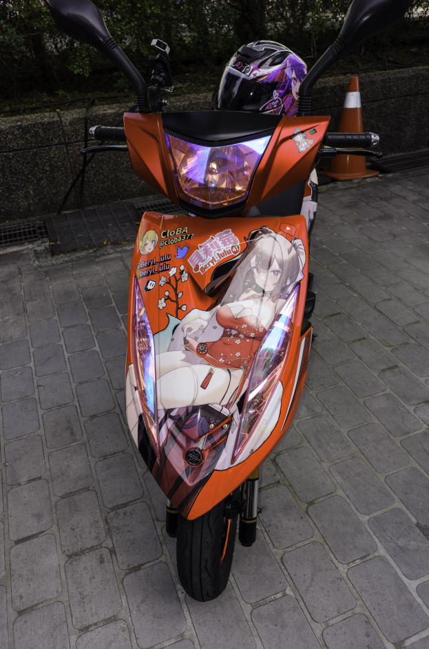 Oranger Roller auf der Straße mit Helm darauf, Verkehrskegel und Bäume im Hintergrund.