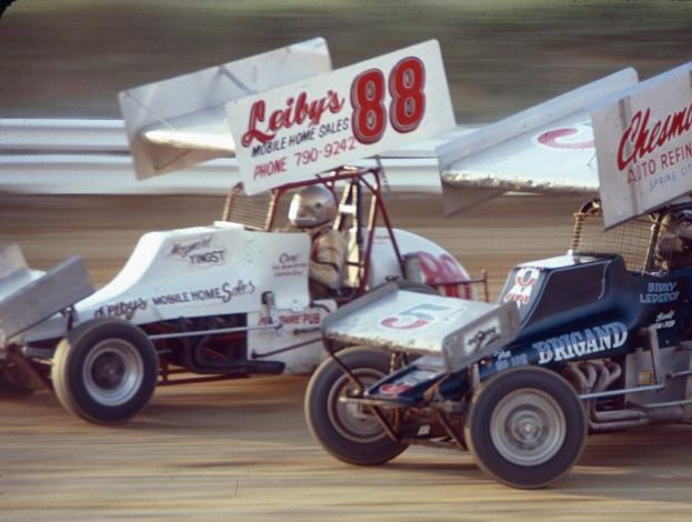 Autos auf einer Straße mit einer Sicherheitsbarriere im Hintergrund, Hintergrund unscharf.