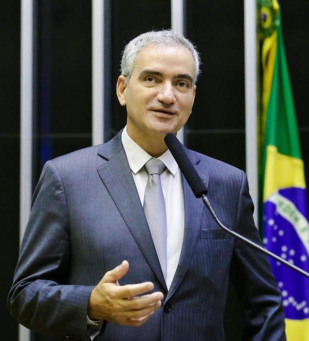 Ein Mann im Anzug spricht an einem Podium mit einer brasilianischen Flagge im Hintergrund, wahrscheinlich über die Suspendierung von Präsident Michel Temer.