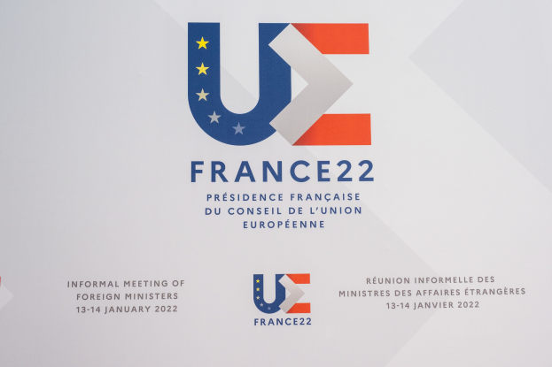 Plakat für die "Frankreich 22 - Informelle Tagung der Außenminister" mit dem Logo der Europäischen Union, das einen blauen Kreis, einen weißen Stern und schwarzen Text auf einem weißen Hintergrund zeigt.