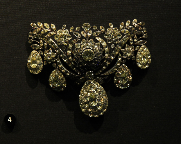Eine goldene und diamantene Brosche mit funkelnden Diamanten in einem Museum ausgestellt.
