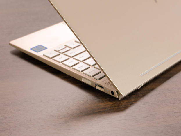 Ein schwarzes Microsoft Surface Laptop 3 mit einem silbernen Logo steht auf einem Holztisch, mit einem 13,3-Zoll-Display, einer vollgroßen Tastatur, einem Touchpad und einem Intel Core i5-Prozessor mit 8 GB RAM und 256 GB SSD-Speicher.