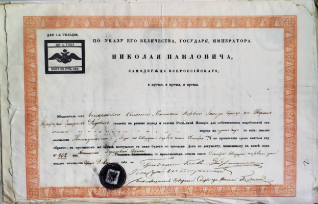 Altes Zertifikatsdokument mit einem Stempel auf einer Oberfläche, mit sichtbarem Text.