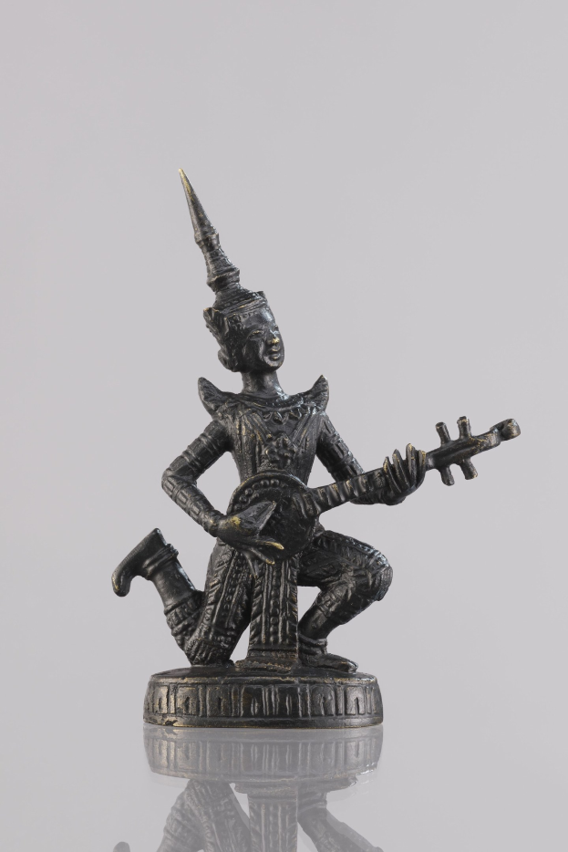 Bronzestatue eines Mannes mit einer Gitarre gegen einen weißen Hintergrund.